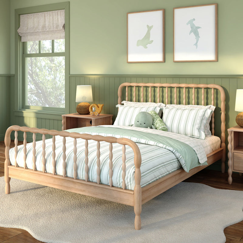 Mint green nursery with wooden spindle bed, mint-striped bedding, plush sea creature toy, framed whale and shark wall art, rattan lamp and wooden nightstand