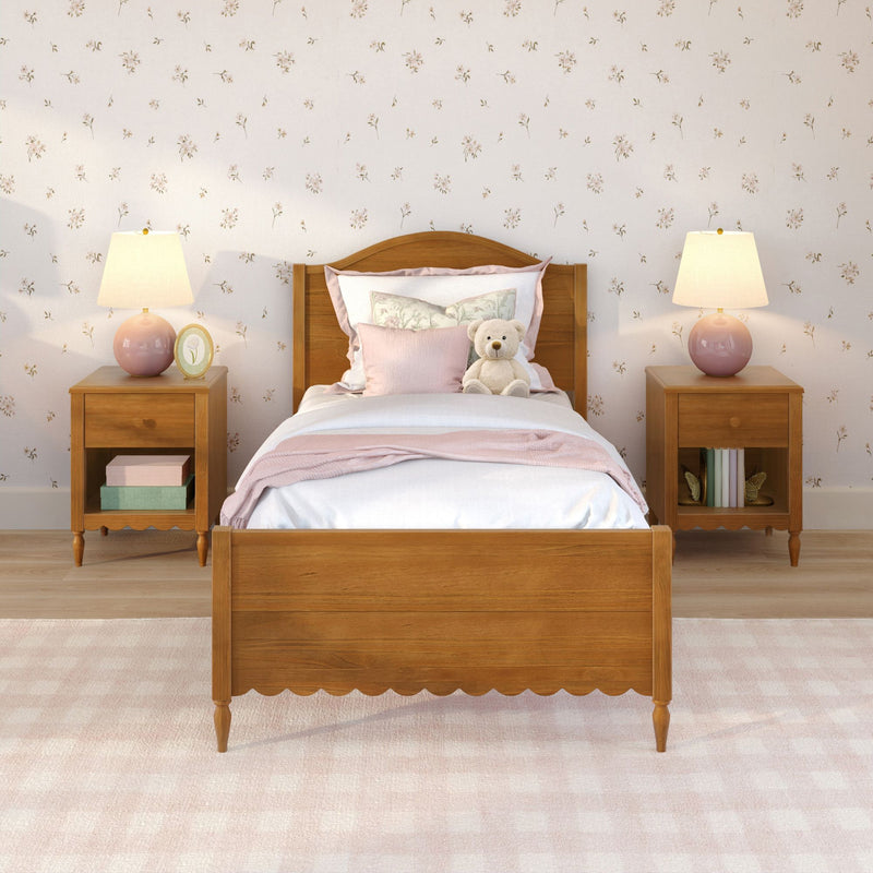 Cozy children's bedroom with wooden twin bed, pink bedding and pillows, teddy bear, matching pink bedside lamps and delicate floral wallpaper