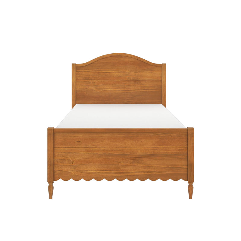 Solid wood bed frame with arched headboard and scalloped footboard in warm honey finish, white mattress, classic farmhouse bedroom furniture scene