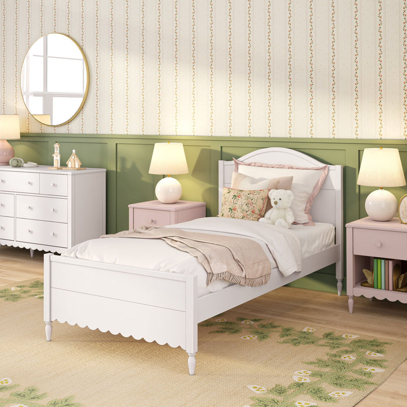 Cozy girls nursery with white wooden toddler bed, floral pillows and teddy bear, pink nightstands, green wainscoting, striped floral wallpaper and table lamps