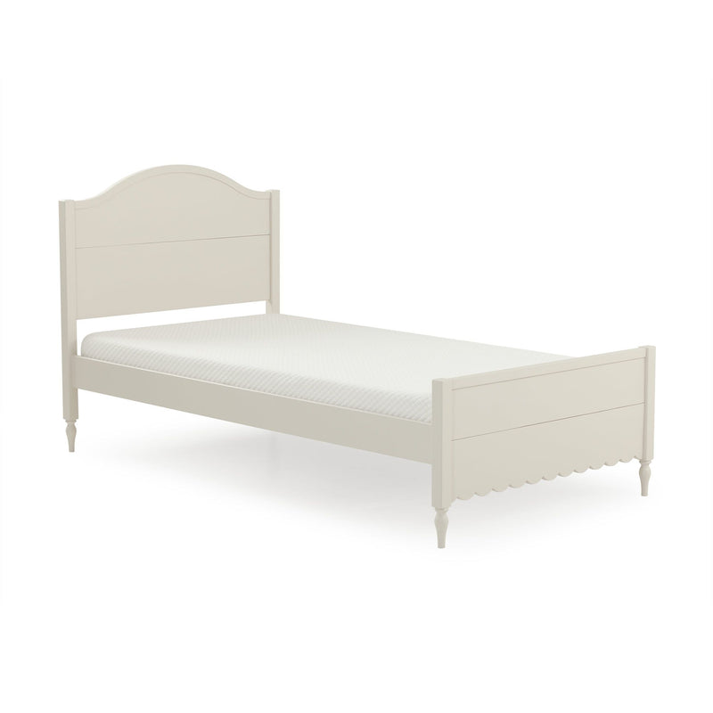 Cream wooden twin bed frame with arched headboard, scalloped footboard, turned legs and white quilted mattress