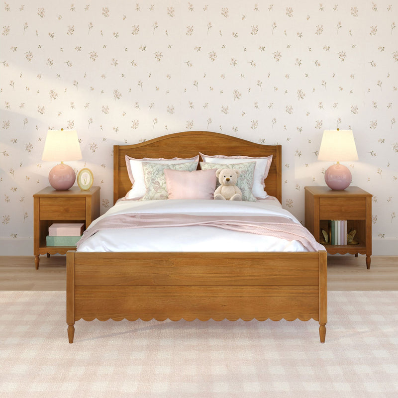 Cozy pastel pink bedroom with wooden bedframe, floral wallpaper, layered pillows and blanket, bedside tables with pink lamps and a teddy bear
