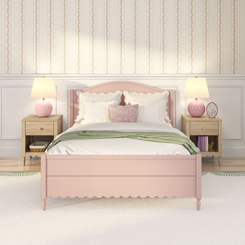 Pastel pink scalloped bed with white bedding and blush velvet pillows in a cozy girls' bedroom with vintage floral striped wallpaper, wooden nightstands and pink table lamps