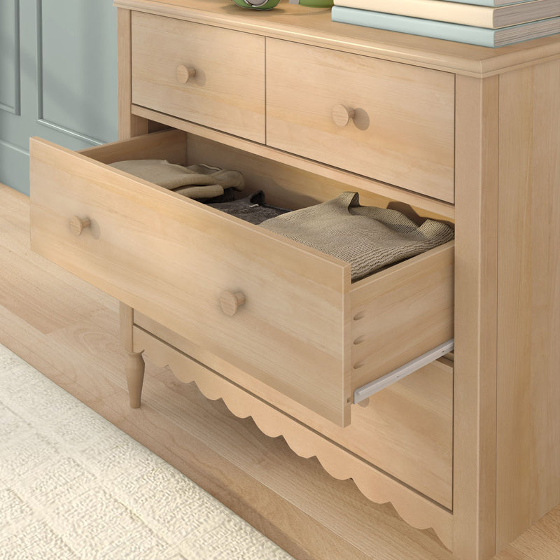 Light maple dresser with open drawer showing folded knit sweaters, bedroom storage nightstand in modern farmhouse style