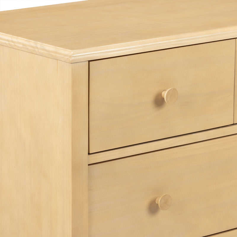 Light wood dresser drawer close-up with round wooden knob and smooth natural maple finish nightstand corner