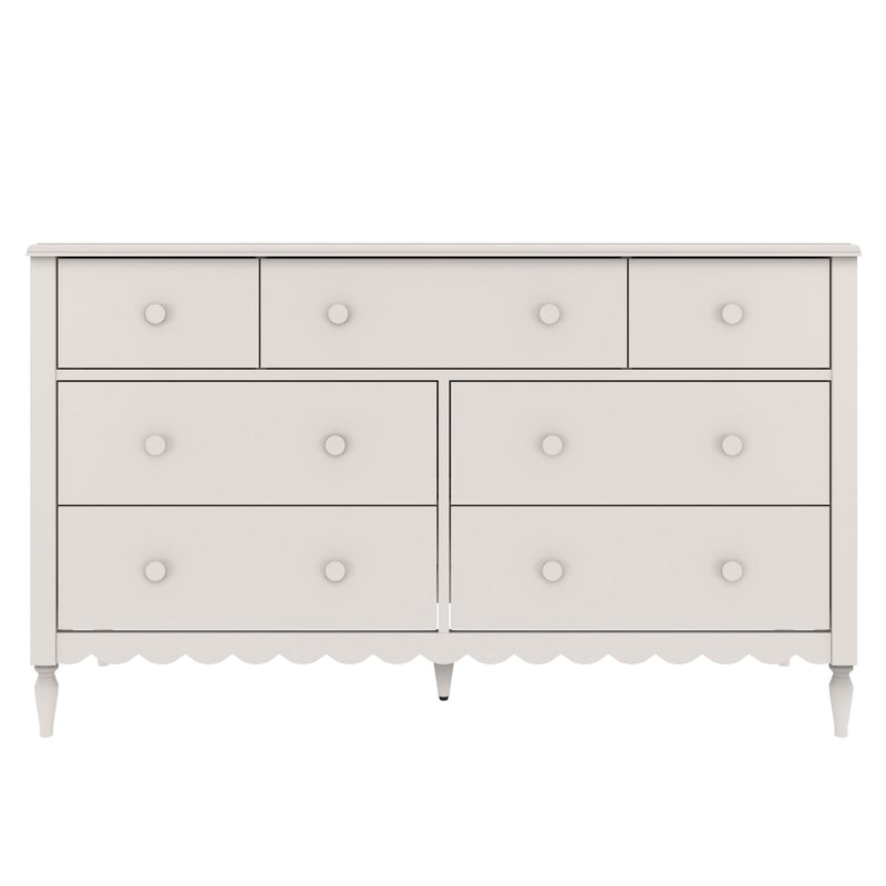 White wooden six-drawer dresser with round knobs, scalloped apron and turned tapered legs, farmhouse-style bedroom storage chest