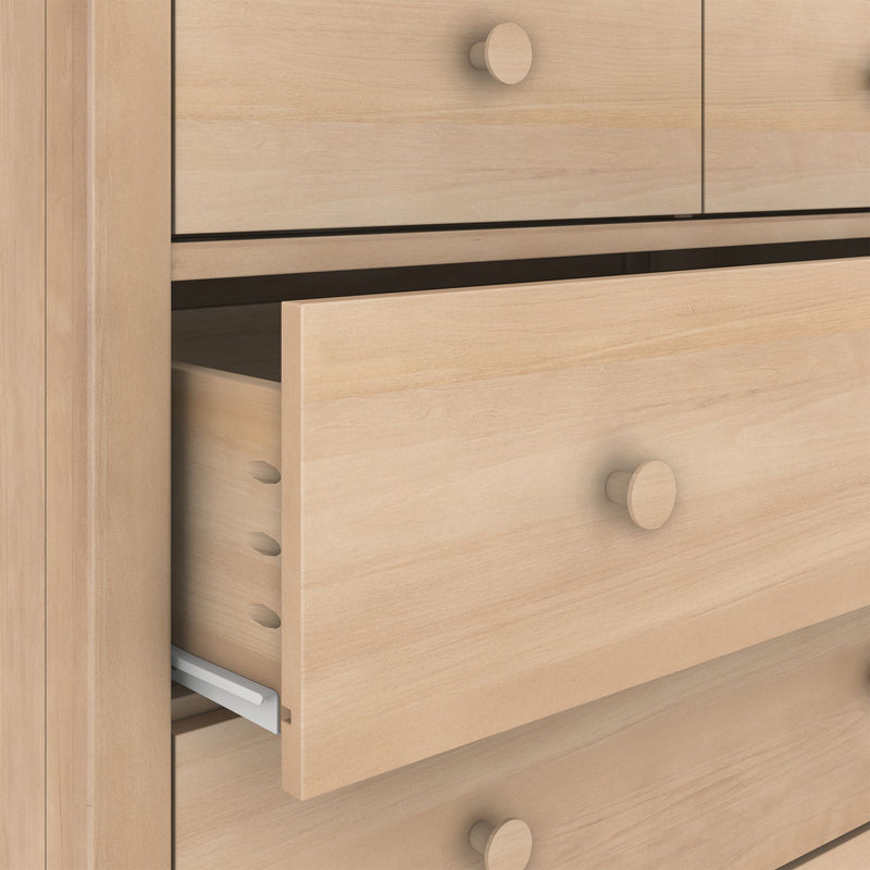 Close-up of light maple dresser drawers showing dovetail joints, wooden knobs and a partially open drawer with metal slide, natural finish bedroom furniture