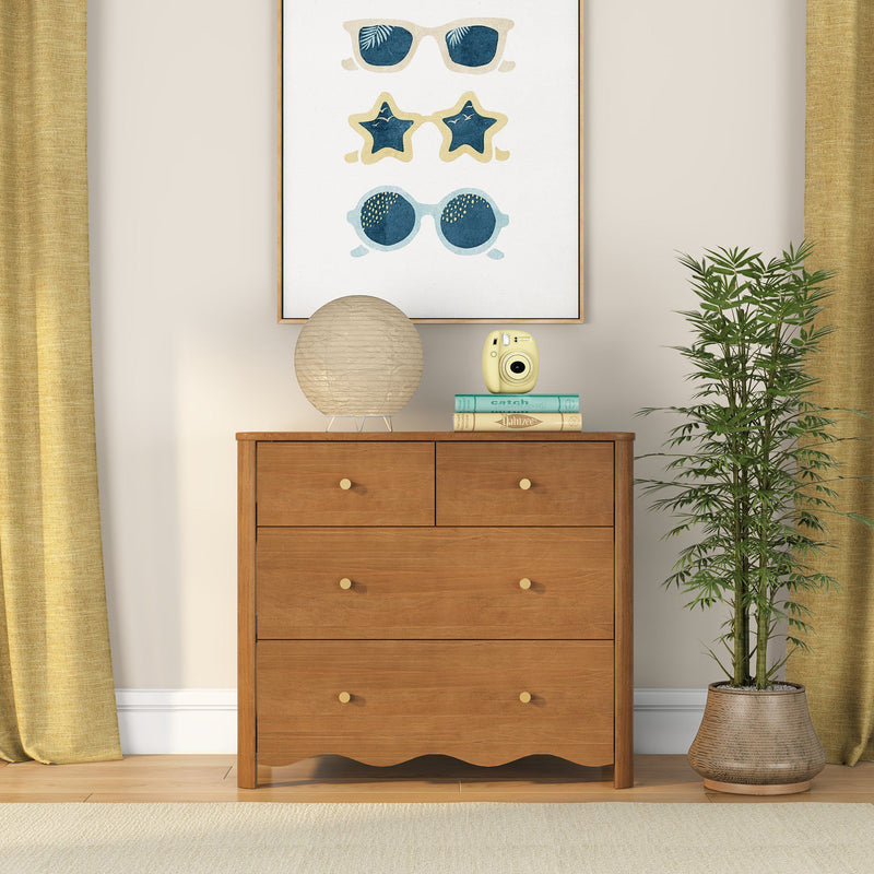 Wooden dresser in cozy home interior with framed sunglasses wall art, round paper lantern lamp, yellow instant camera, stacked books and potted plant