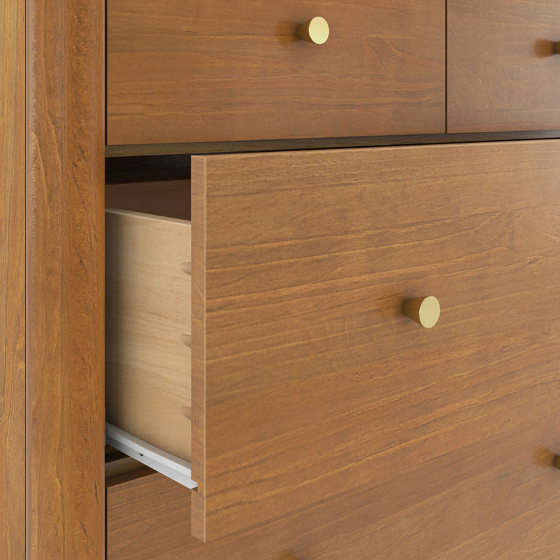 Close-up of a partially open light brown wooden dresser drawer showing wood grain texture, dovetail joinery, metal drawer slides and round brass knob — modern bedroom storage furniture