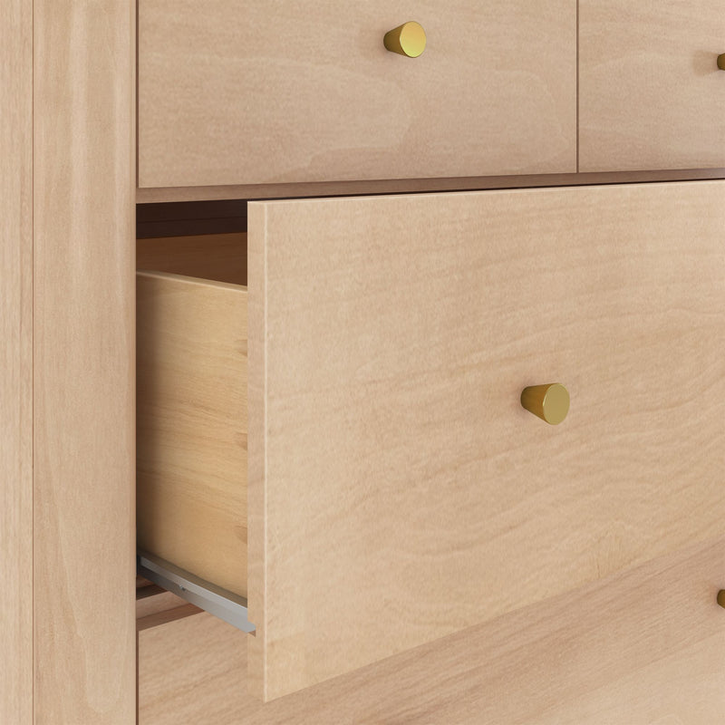 Close-up of light maple dresser with partially open drawer, brass knobs, visible wood grain and metal drawer slide