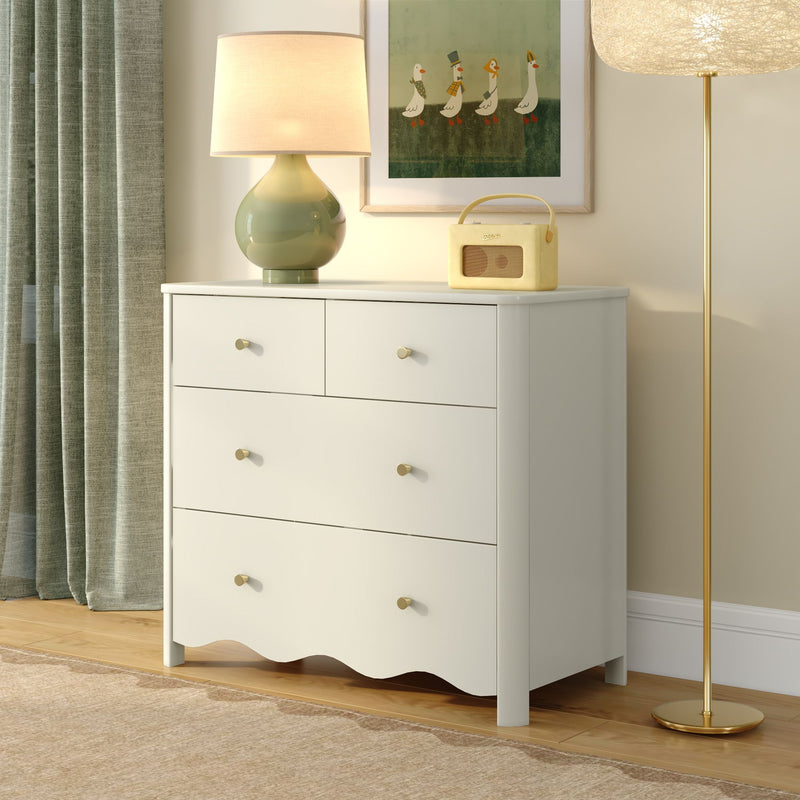 White dresser with green ceramic table lamp, yellow retro radio, framed duck artwork and gold floor lamp in modern neutral bedroom