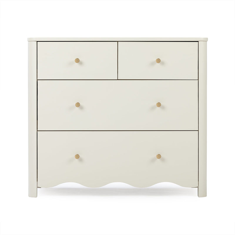 Cream wooden chest of drawers with round brass knobs, scalloped apron and clean modern nursery design