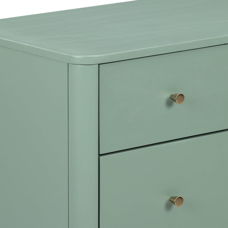 Sage green modern dresser close-up showing rounded top corner, matte painted finish, drawer fronts and brass cone knob