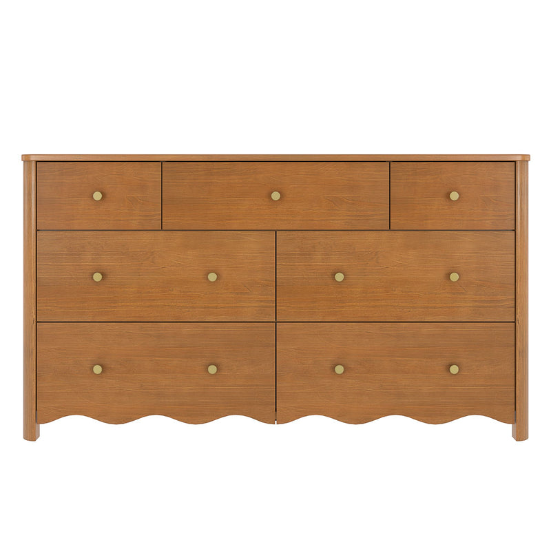 Six-drawer wooden dresser in warm oak finish with round brass knobs and scalloped apron, modern farmhouse chest of drawers on white background