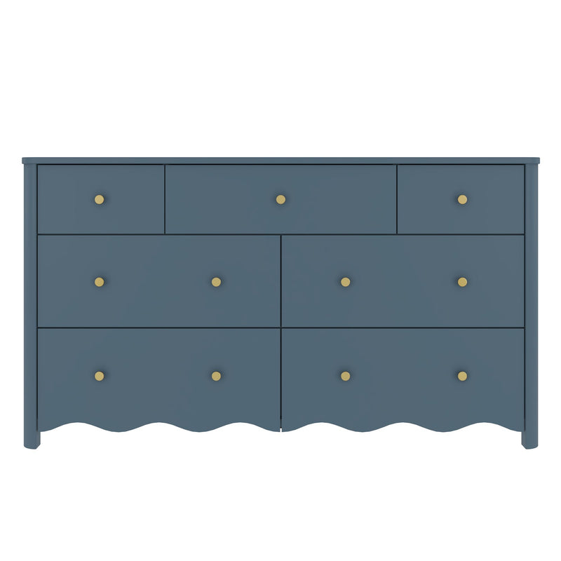 Matte blue painted wooden dresser with brass knobs and scalloped skirt, multi-drawer bedroom storage chest in coastal-modern style