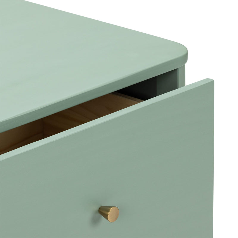Close-up of mint green wooden dresser drawer with brass knob and rounded top edge, modern minimalist bedside chest detail