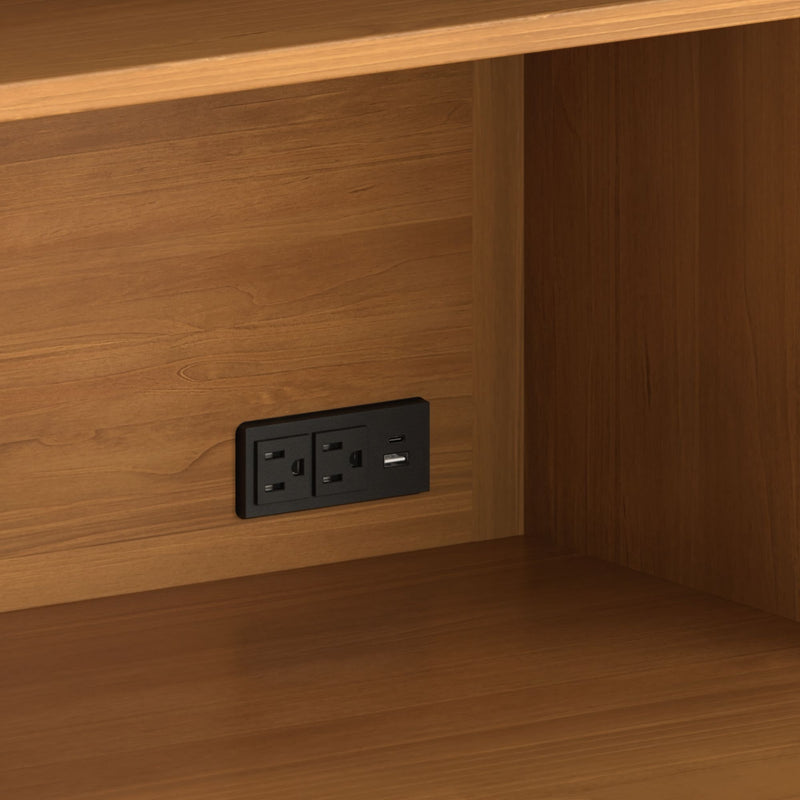 Close-up of wood cabinet shelf interior with recessed black power outlet featuring two AC sockets and dual USB charging ports