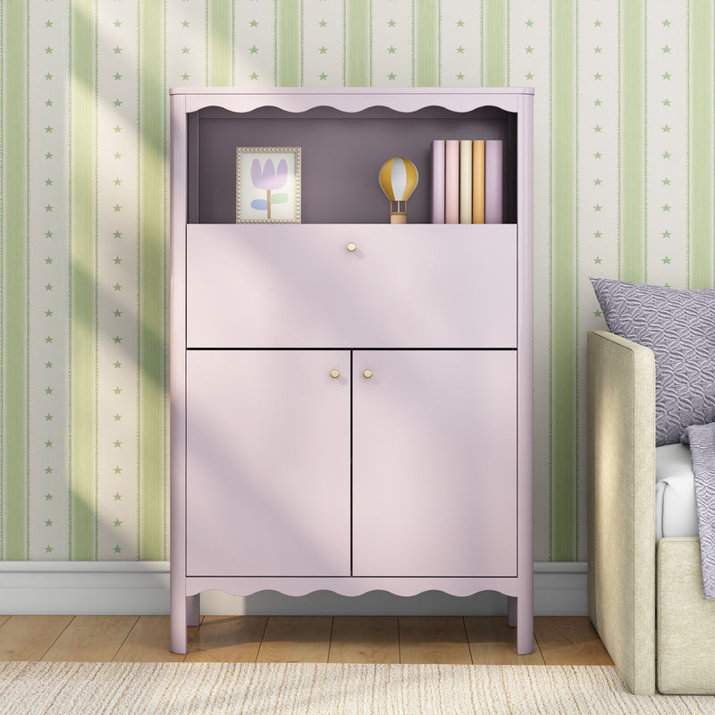 Pink nursery cabinet with scalloped shelf holding framed tulip print, wooden hot-air-balloon toy and pastel books against green star-striped wallpaper — children's room storage and decor