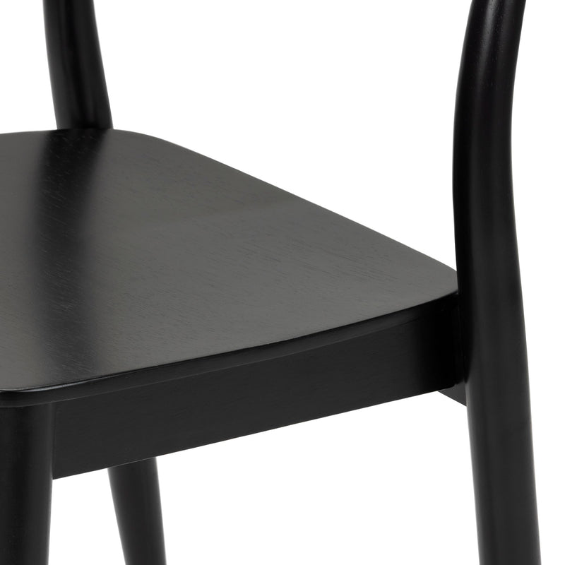 Close-up of black wooden dining chair seat and rounded legs, modern matte-finish kitchen chair detail