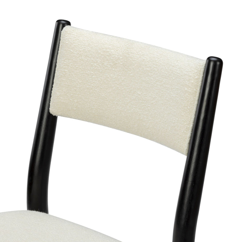 Close-up of modern dining chair backrest with cream textured upholstery and black wooden frame