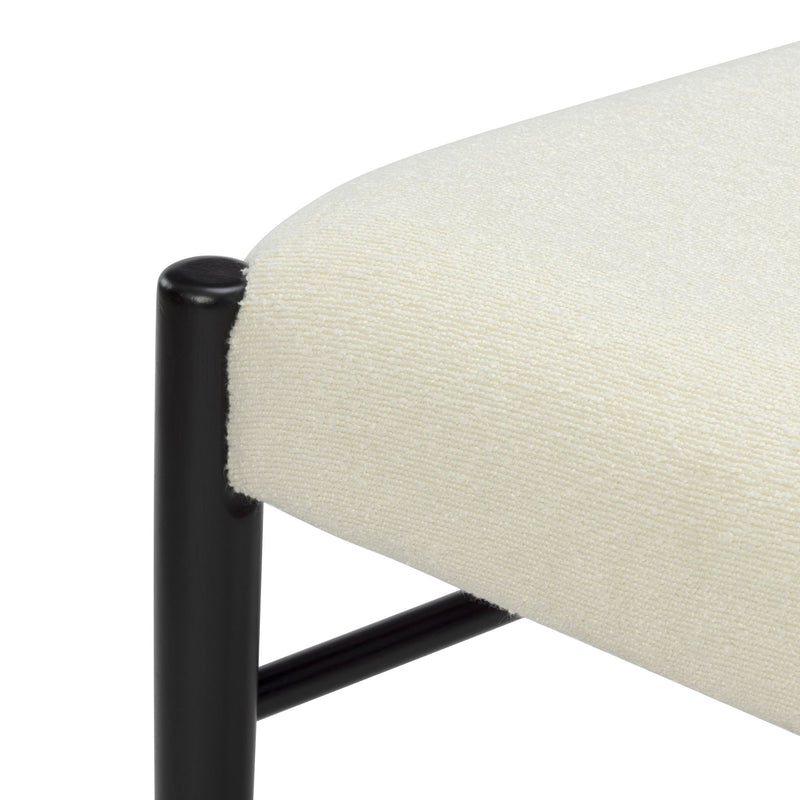 Close-up of cream boucle upholstered bench seat with black metal legs, modern accent stool for minimalist living room furniture