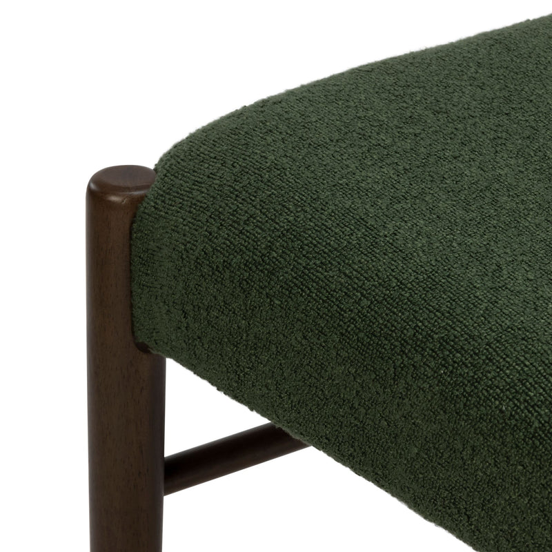 Close-up of green boucle upholstered chair seat with dark walnut wooden frame, textured fabric detail for mid-century modern dining or accent chair