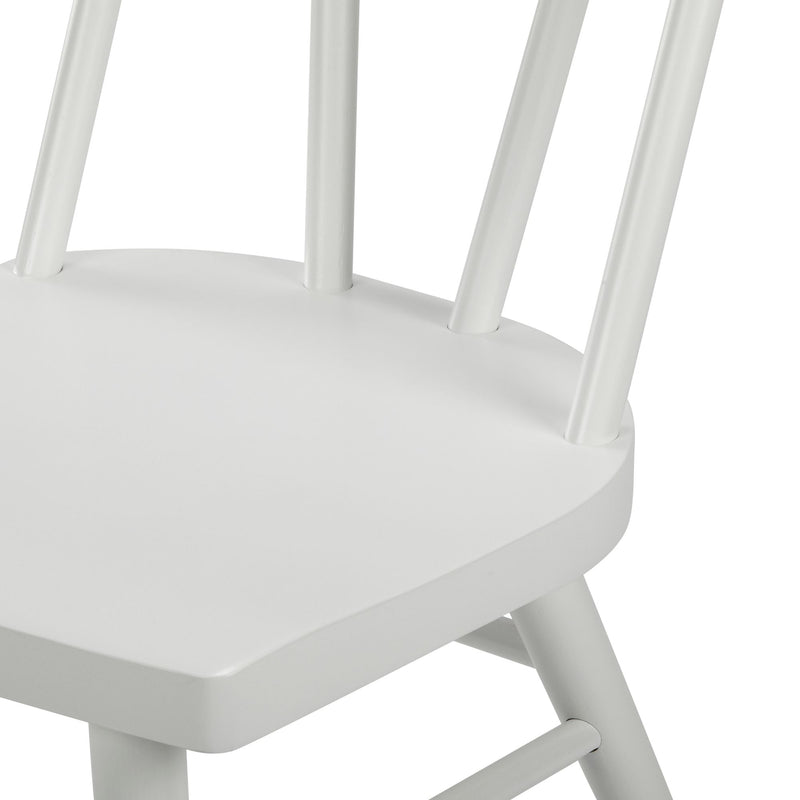 Close-up of white painted wooden spindle-back dining chair seat and legs with matte finish, modern farmhouse style