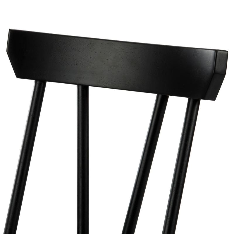 Close-up of black wooden dining chair backrest with spindle back, matte painted finish, modern farmhouse style
