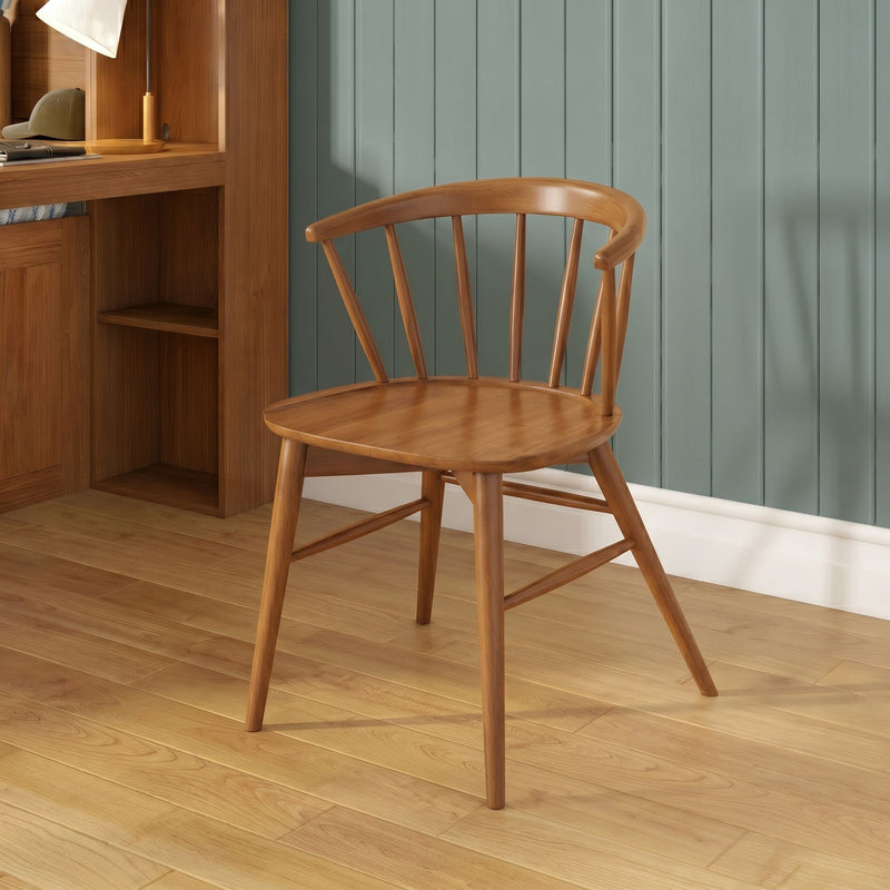 Mid-century wooden spindle chair beside oak built-in desk with lamp on hardwood floor against light blue vertical paneled wall