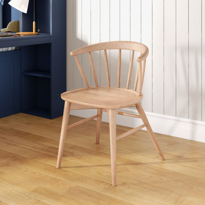 Light wood spindle-back chair in Scandinavian dining nook next to a navy built-in desk, white shiplap wall and oak hardwood floor