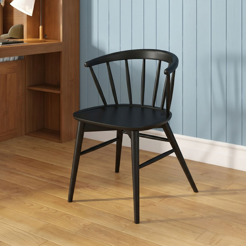 Black wooden spindle-back chair in a modern home office with light blue vertical paneled wall, walnut desk, task lamp and oak hardwood floor