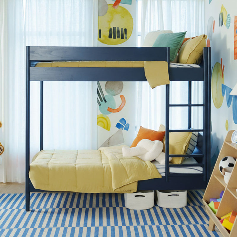 Navy kids bunk bed with yellow bedding, ladder, striped blue rug, storage baskets and colorful wall decals