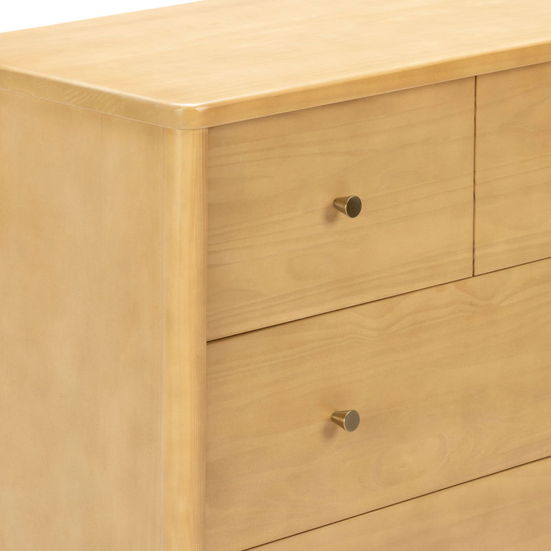 Close-up of light maple wood dresser with rounded top edge and brass knob, minimalist modern bedroom dresser with smooth natural finish
