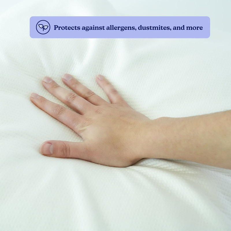 Hand pressing soft white hypoallergenic mattress protector to show memory-foam contour, breathable fabric and dust mite allergen protection