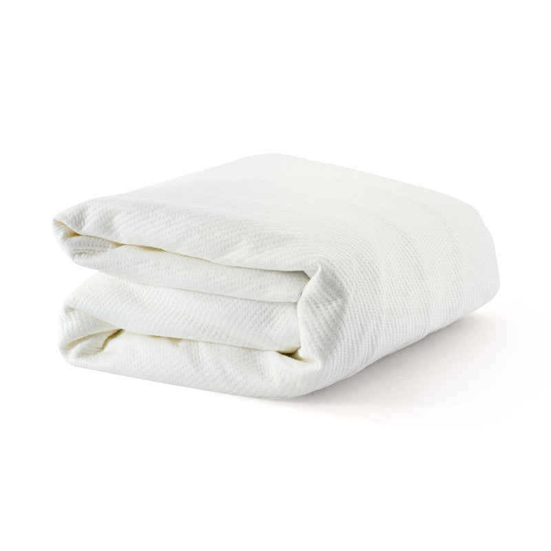 Folded white waffle-textured mattress protector pad on white background, soft breathable mattress pad for bed