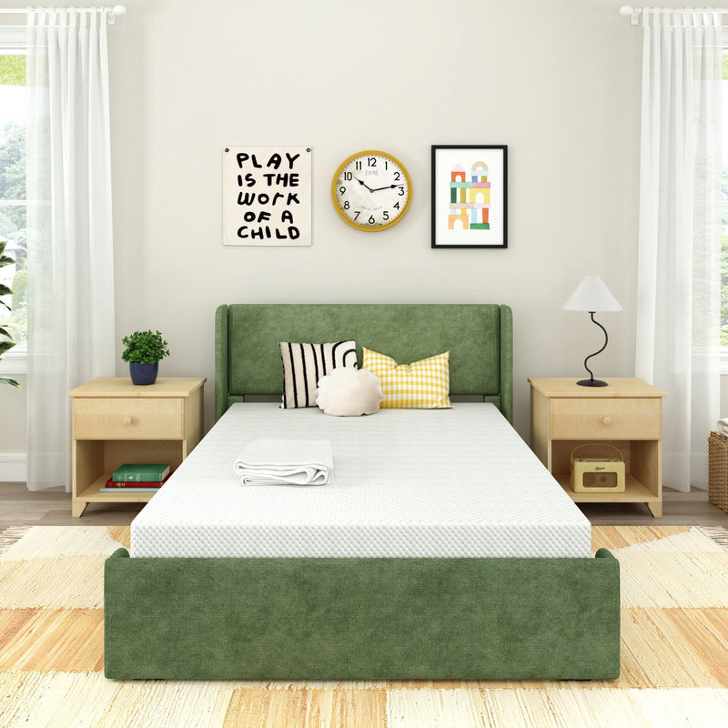 Bright minimalist bedroom featuring a green upholstered platform bed with white mattress, wooden nightstands, decorative pillows, wall clock and framed children's artwork reading "Play is the work of a child