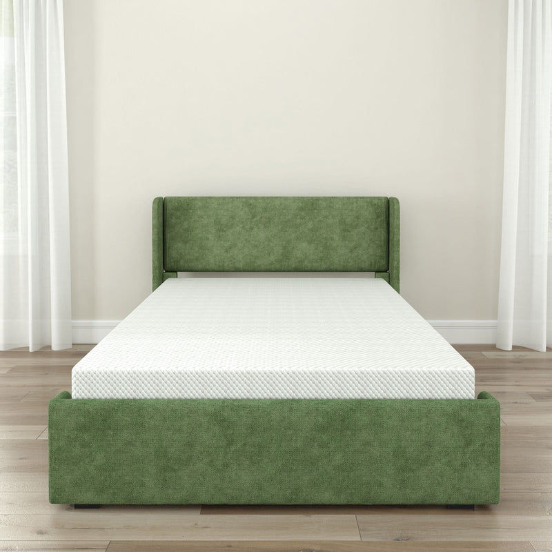 Green upholstered bed frame with white mattress in a minimalist modern bedroom on hardwood floors with sheer white curtains