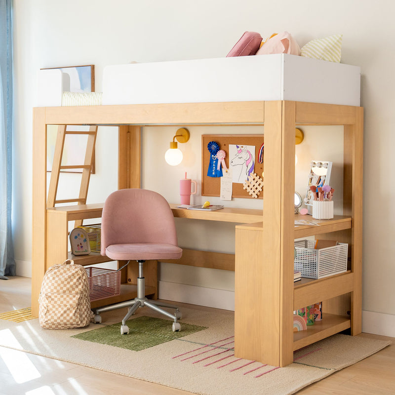 Kids wooden loft bed with built-in desk and ladder, pink swivel chair, corkboard with ribbons and storage shelves — modern children's study nook and bedroom decor