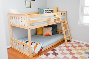 Twin over twin bunk bed with solid natural wood in bright kids bedroom with decor