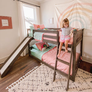 Low bunk bed with slide in brown clay finish in girls room
