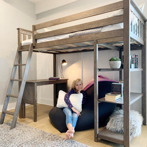 Twin loft bed with desk and bookshelf storage in neutral girls room