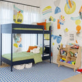 Modern kids' bedroom with navy bunk bed, green bedding, colorful abstract wall mural, wooden toy storage shelf and striped blue rug