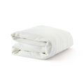White knitted blanket folded neatly, showcasing a soft texture, ideal for cozy home decor and comfort.