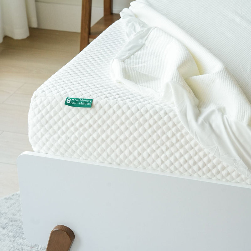 8-inch gel memory foam mattress with white bedding on a wooden bed frame in a bright room.