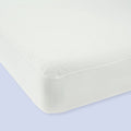 Mattress with a white fitted sheet on a light blue background.