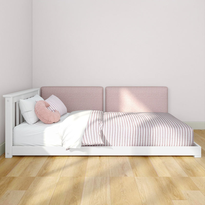 Minimalist modern bedroom with white wooden platform bed, pink upholstered headboard, pink striped bedding, round pink cushion, hardwood floor