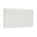 Close-up of white textured boucle fabric upholstered headboard corner with rounded edge, modern bedroom décor detail