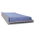 Gray pull-out trundle bed with twin mattress and blue geometric fitted sheet, space-saving underbed guest bed