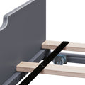 Close-up of metal bed frame with wooden slats, caster wheel, metal support bracket and black stabilizing strap for platform bed