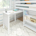 White kids loft bed with built-in desk and storage shelves by a sunny window, cozy study area with books and colored pencils